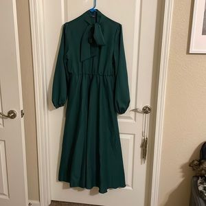 Emerald green midi dress with bow tie collar and bell sleeves.